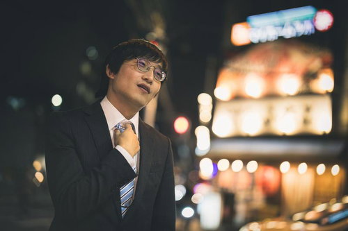 ネクタイを締めて夜の街で次の店へ向かう会社員
