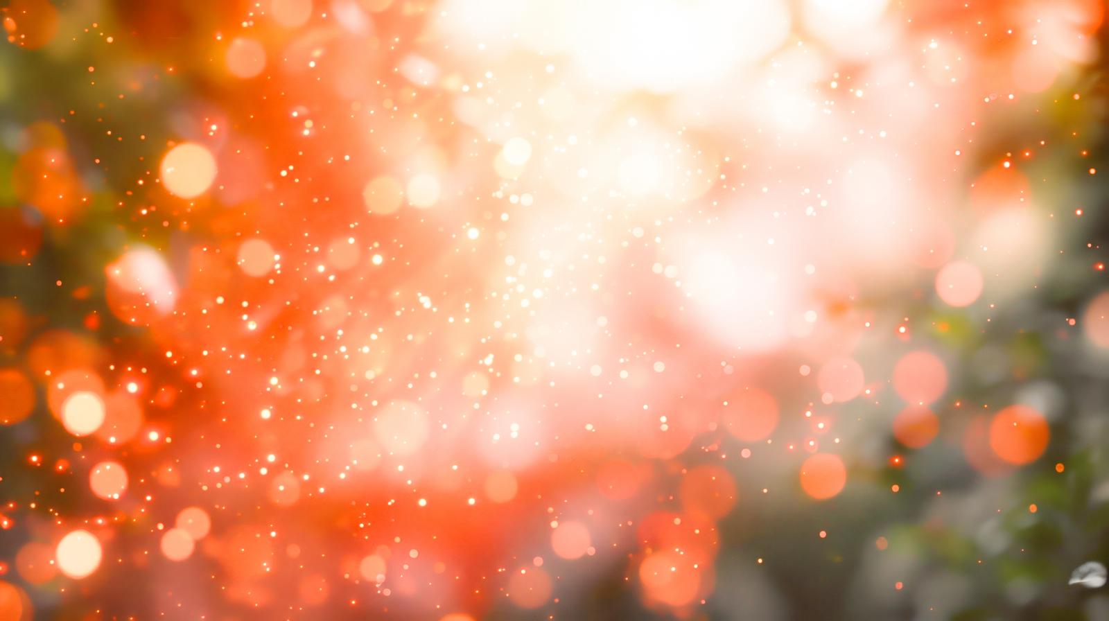 オレンジの光が弾け散り、無数の玉ボケが煌めく画像