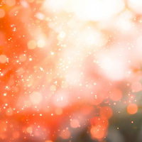弾け散るオレンジの光源と煌めき、玉ボケが浮遊する輝く背景の写真