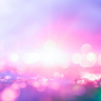 ピンク紫に煌めく光の粒が広がる色彩背景グラデーションの写真
