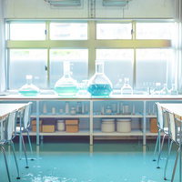 学校の理科室風実験室でビーカーに入った化学液体の写真