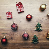 木製テーブルに並べたクリスマスオーナメントと贈り物の写真