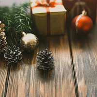 木目テーブルに飾るクリスマスのオーナメントとプレゼントの写真