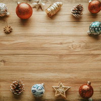 木製テーブルに並べたクリスマスオーナメントと松ぼっくりの写真