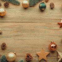 木製テーブルに並ぶクリスマスオーナメントと松ぼっくりの写真