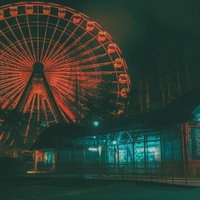 深夜の遊園地に浮かぶ薄気味悪い観覧車とネオン照明の写真