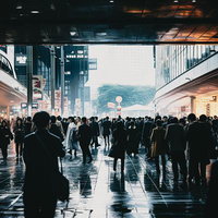 雨に濡れた駅前の通勤時の群衆と都会の朝の風景の写真