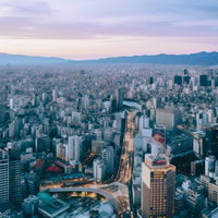 夕焼けに染まる大都会の街並み・俯瞰した高層ビル群と街灯の夜景の写真
