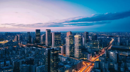 夕焼けに染まるビル群と車の流れ、都市交通の動き