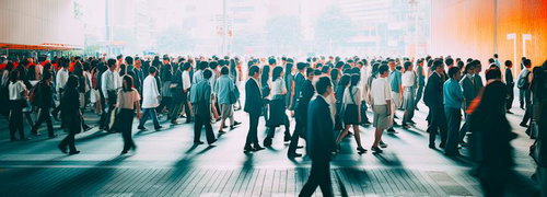 朝日に照らされた駅前の人であふれる出勤姿