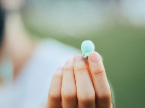 手のひらに置かれた水色のイヤホン、遺失物・落とし物の