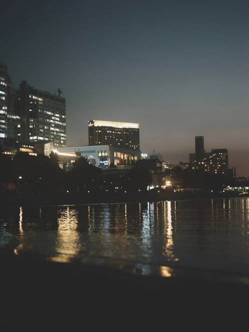 河岸のビル群の明かりが水面に映り込む夜景