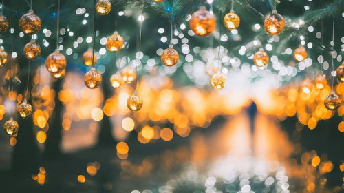 クリスマスの夜、緑の樹に吊るされたキラキラと煌めくゴールドのオーナメントボール