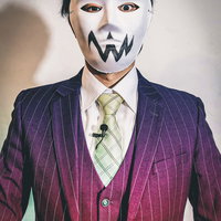 紫のストライプスーツに白い仮面の怪しい人物の写真