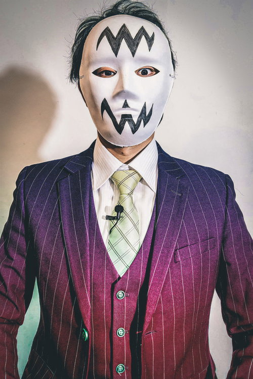 紫のストライプスーツに白い仮面の怪しい人物