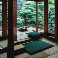 畳ある和室から障子越しに望む日本庭園の風景の写真