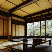 庭園を望む畳敷きの和テイストの応接間、障子と黒木の日本建築空間の写真