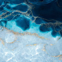 揺れる水面に浮かぶ金の砂と青い大理石風の流れの写真