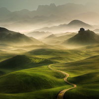 朝靄が立ち込める高原の丘から望む雄大な山並みの写真