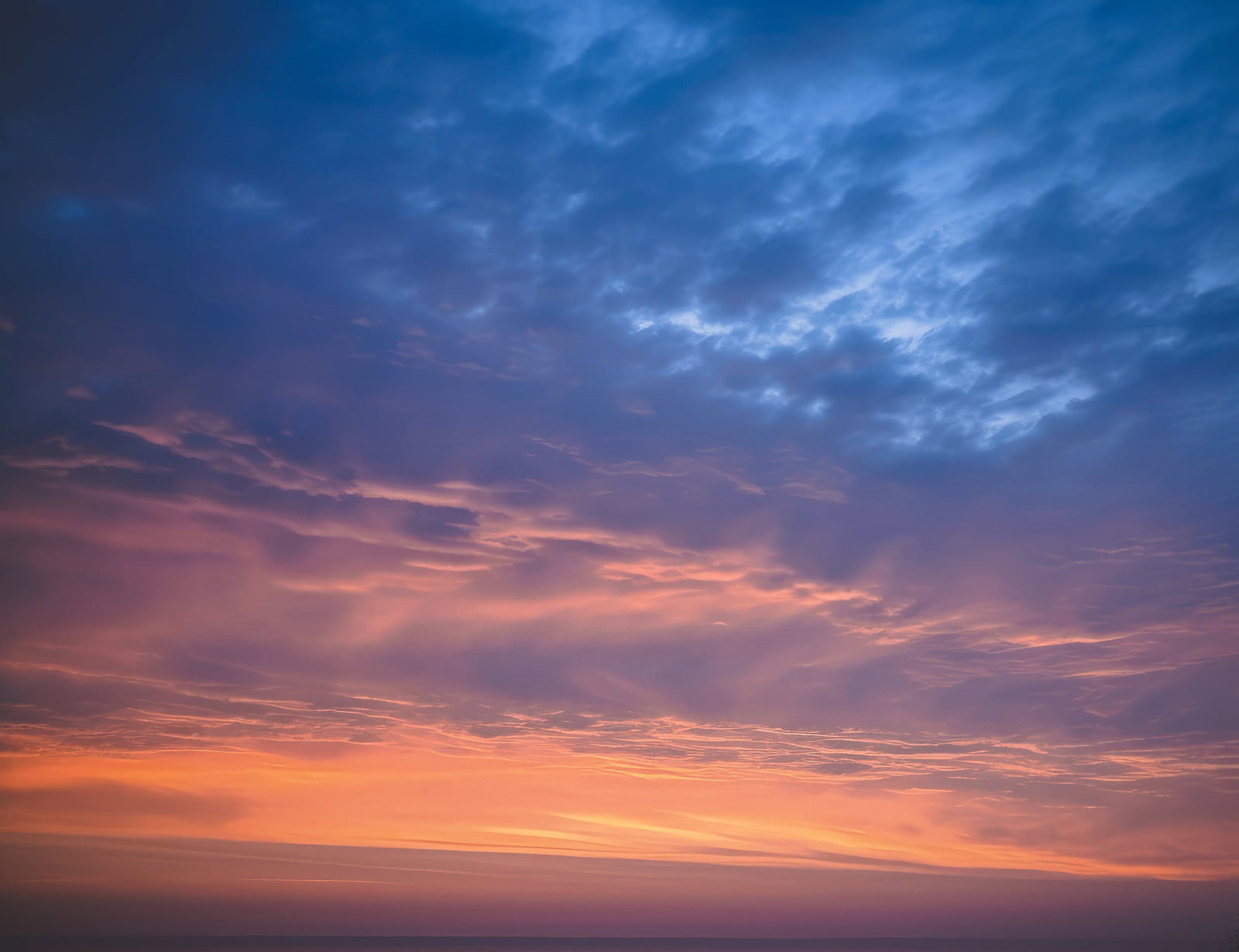 オレンジから青へ段階的に変わる夕焼けのグラデーション空
