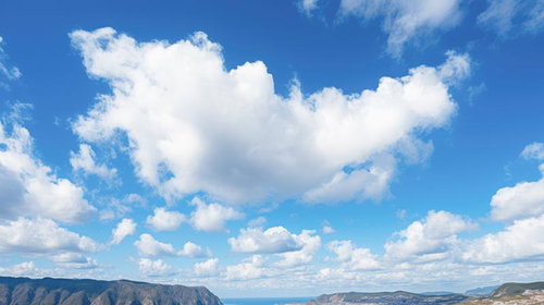 島と青空と白い雲が映る海辺の風景、山々が連なる自然景観