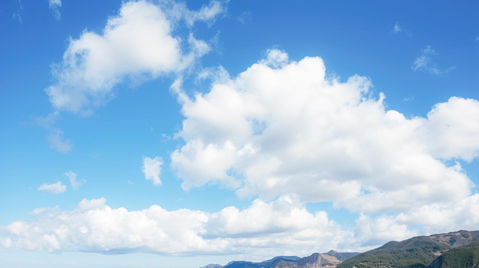 青空を背景に白い大きな雲が浮かび、下に島々が見える風景