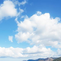 青空に浮かぶ大きな雲と島々の風景の写真