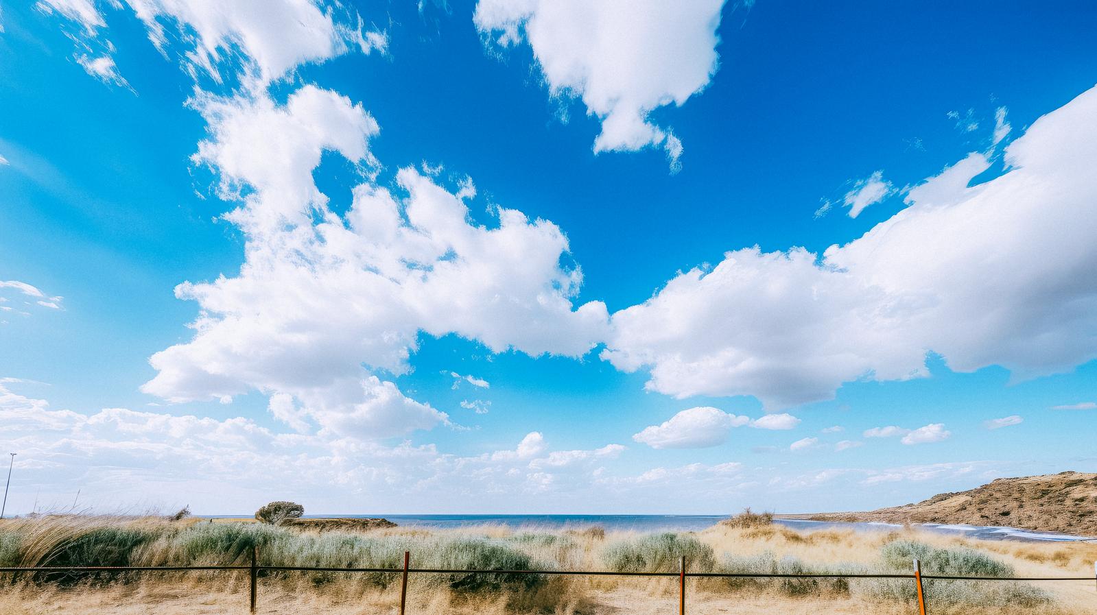 青空と白い雲が広がる晴れた夏日の島の海岸