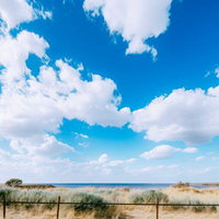 よく晴れた夏日の島の海岸線で見る青い空と波打ち際の風景の写真