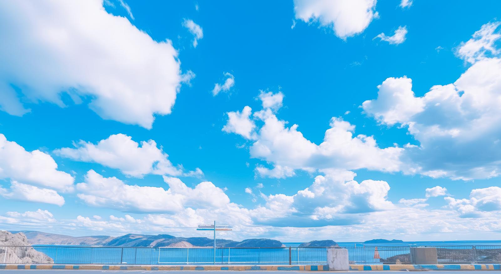 展望台の柵越しに見た青い海と島々を望む晴れた景色