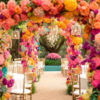 ピンク・オレンジ・赤の花が咲き乱れるフラワーアーチの写真