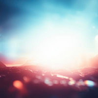 山並み越しの朝日とレンズフレアのライトリークの写真