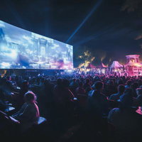 大勢が集う夜間のパブリックビューイング会場の写真