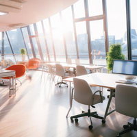 朝日が差し込むガラス張りのオフィスラウンジ空間の写真