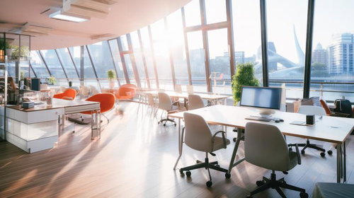 朝日が差し込むガラス張りのオフィスラウンジ空間