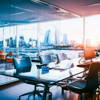 都市景観を眺めるオフィスビル内のデスク・ワークスペースの写真