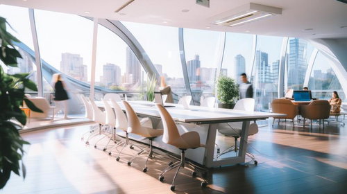 自然光が差し込む高層オフィスのデスクと都市景観