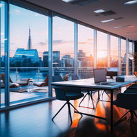 夕焼けに染まる都市景観を眺めるオフィスのデスクの写真