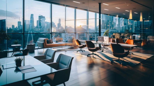 高層ビルの景色を背に広がるガラス張りのオフィスの夕暮れ