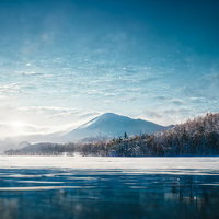 雪山と湖畔に映る冬の風景 澄んだ青空と水面のリフレクションの写真