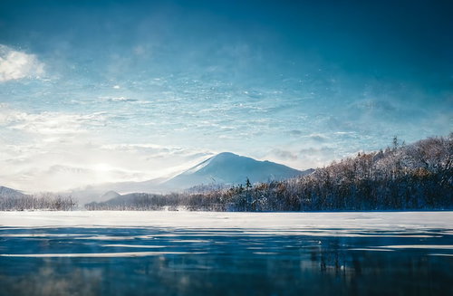雪山と湖畔に映る冬の風景 澄んだ青空と水面のリフレクション