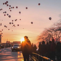 夜明けの街並みを彩るカラフルなバルーンと人群れの写真