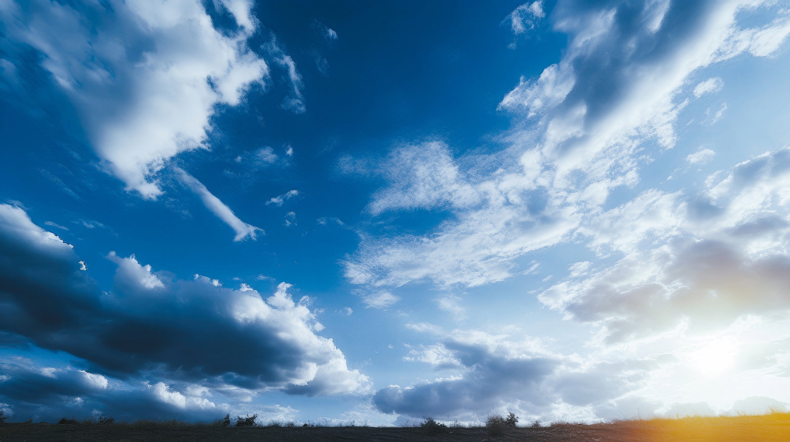 白い雲が浮かぶ深い青色の空が広がる晴天の風景