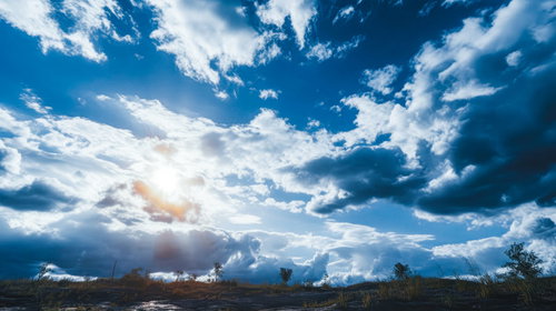 日中の雲が浮かぶ青空と原っぱの日の入り風景