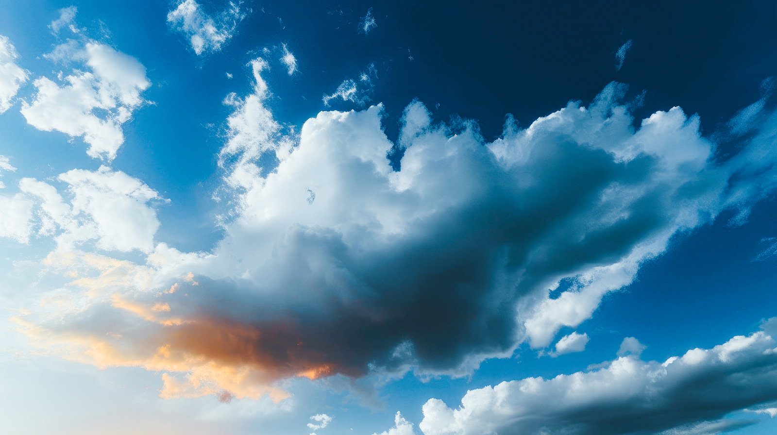 日の入りの光に照らされる雲と青空の風景