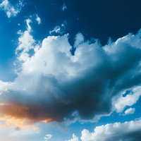 日の入りの光が照らされる雲と青空の写真