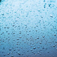 雨粒のついたガラス面の水滴クローズアップの写真