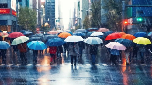 雨の都市で傘をさした集団の通勤ラッシュ、梅雨時期の悪天候