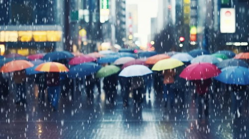 カラフルな傘を差して雨の中を歩く人混みの都市風景
