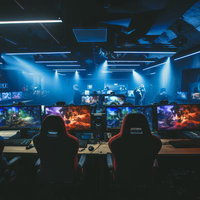 青い照明に照らされたズラリと並ぶPCゲーム機のeスポーツ施設の写真